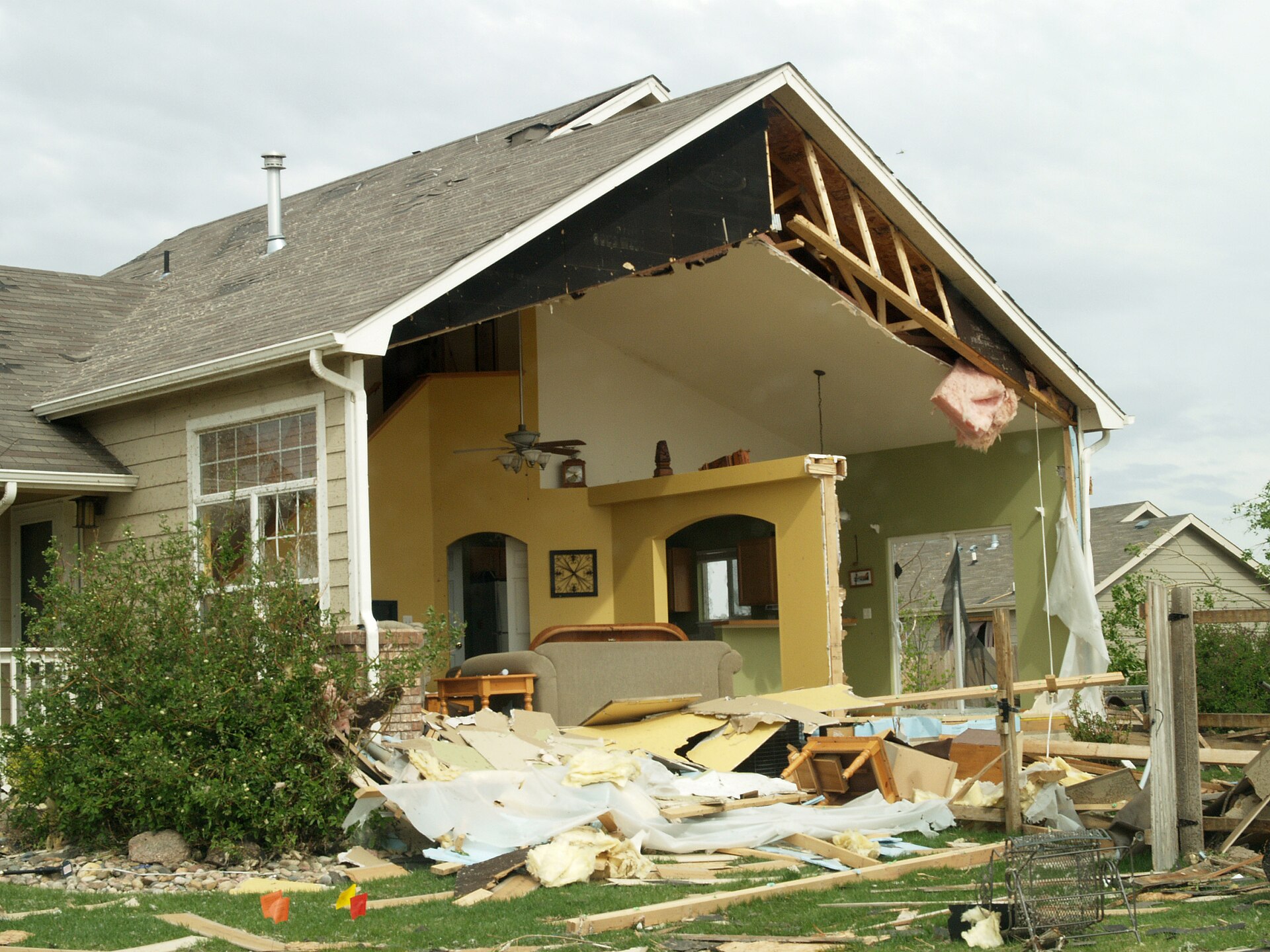 Roof opened over a house, rafters bare. Temporary still.